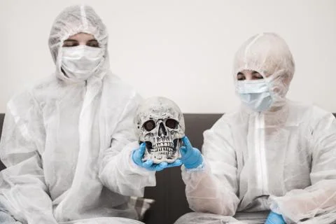 Two people in protective white translucent suit, blue rubber gloves, medical Stock Photos