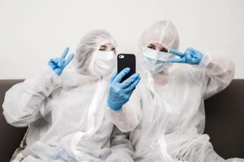 Two people in protective white translucent suit, blue rubber gloves, medical Stock Photos