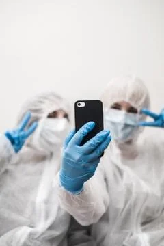 Two people in protective white translucent suit, blue rubber gloves, medical Stock Photos