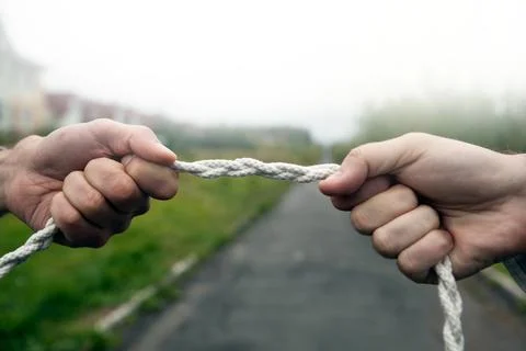 Two people pull the rope against each other Stock Photos