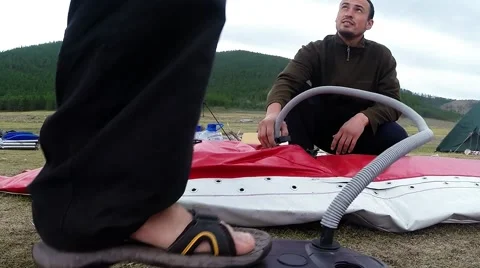 Two People Pumped Pylon of Boat With a Pump in the Highlands Close up Stock Footage 61173286