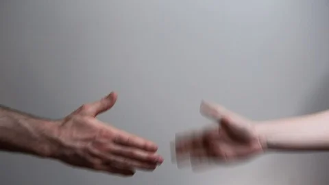 Two people put on latex gloves in order to shake hands safely during the Stock Footage 128498694