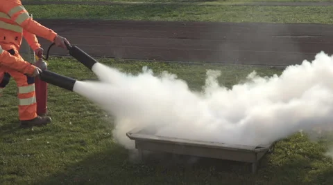 Two people putting out a fire with fire extinguishers. Stock Footage 57627427
