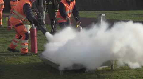 Two people putting out a fire with fire extinguishers. Stock Footage 57629664