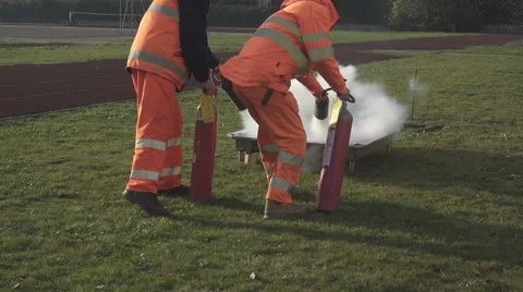 Two people putting out a fire with fire extinguishers. Stock-Footage 57630015