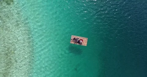 Two people on a raft float in colorful clear water Stock Footage 86130403