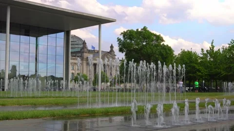 Two people with rainbow and bisexual pride flag running through water fountain Stock Footage 159661214