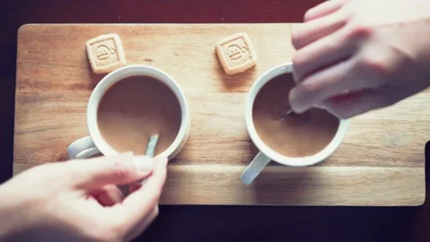 Two people remove two lattes on a table with a spoon and then drink it. 스톡 동영상 130867088