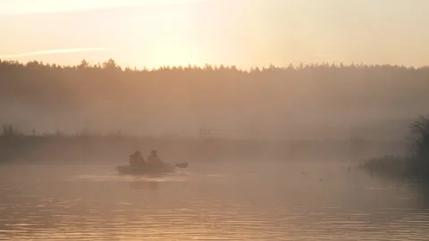 Two people rowing inflatable boat on foggy lake at sunrise Vidéo 341575485