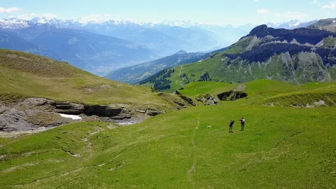 Two people running on a mountain meadow in the mountains Stock Footage 128716675