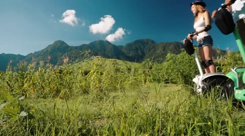 Two people on segway side by side in Pemuteran hills and mountains, low angle Video stock 65301309