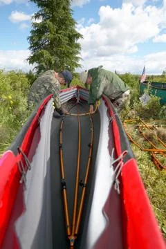 Two people setting up a folding canoe in the wild Stock Photos
