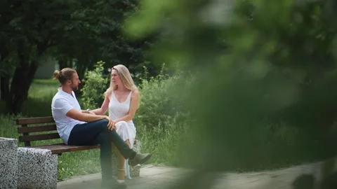 Two people share affectionate conversation outdoors Stockbeeldmateriaal 340887103