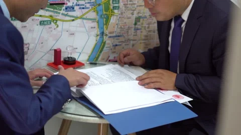 Two people signing contracts at their desks Stock Footage 160418253