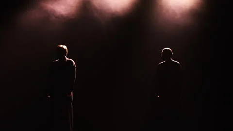 Two People Silhouettes Standing on Dark Stage Under Spotlights Vídeos de archivo 345099943