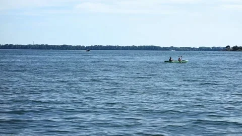Two people sit and row in a kayak on the lake Stock Footage 138013253