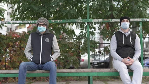 Two people sit at a bus stop during the quarantine period. Stock Footage 142142080