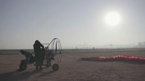 Two People Sit In A Paraglider Aircraft Before Flight On An Airfield Runway Stock Footage 170881453