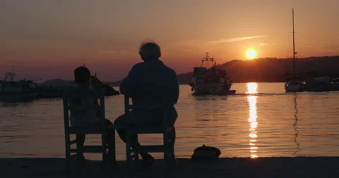 Two people sit on the pier at sunset 库存影片 220547678