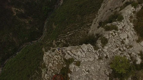 Two people sitting and talking on the top of cliff over a rocky gorge and a Video stock 100551237
