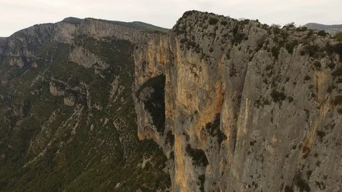 Two people sitting and talking on the top of cliff over a rocky gorge and a Stock Footage 101598087