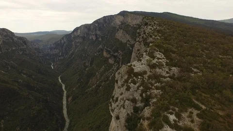 Two people sitting and talking on the top of cliff over a rocky gorge and a Stock Footage 101598590