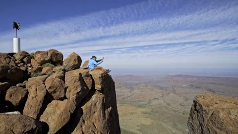 Two people sitting on the edge of a rock in Karoo National Park Stock Footage 310317731
