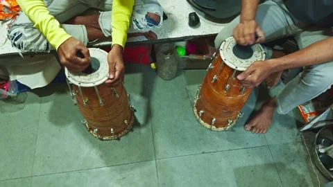 Two people sitting on the floor playing traditional drums with a focus on h.. Stock Footage 266396857