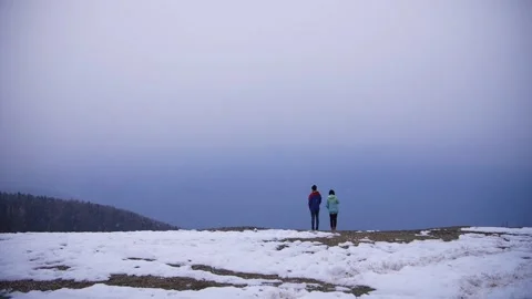 Two people stand against the backdrop of mountains in winter Video stock 232722876