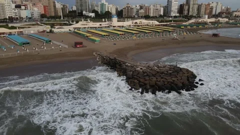 Two people stand in beach breakwater of rocks front to ocean. Mar del Plata C Stock-Footage 152500547