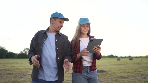 Two people standing in field with tablet. Woman and man working in a field with Video stock 319322091