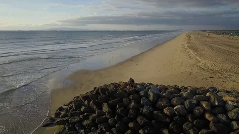 Two People Standing On Ocean Jetty Aerial Orbit 4K Stock Footage 71892188