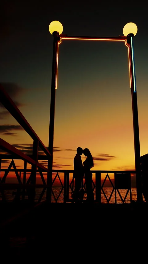 Two people standing on the shore of a tropical island and kissing each other. Video stock 318570853