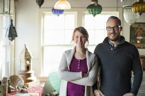 Two people standing in a store full of antique objects, a couple running a bu Stock Photos