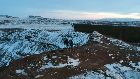 Two people standing on winter edge - drone zoom out Stock Footage 107883769