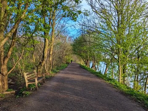 Two people strolling on the Thames Path under a sunny blue sky Stock Photos