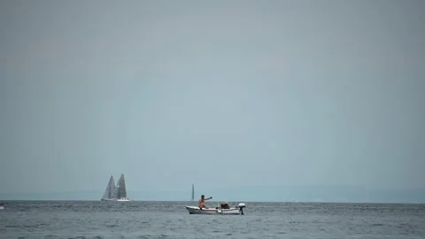 Two people sunbathing on a small boat in the foreground Stock Footage 159018409