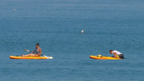 Two people on SUP boards Stock Footage 276376773
