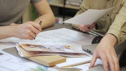 Two people at the table discuss materials for the interior. Stock Footage 79333872
