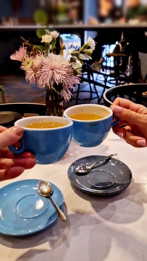 Two People Toasting with Tea Cups in Cafe Stock Footage 321942426