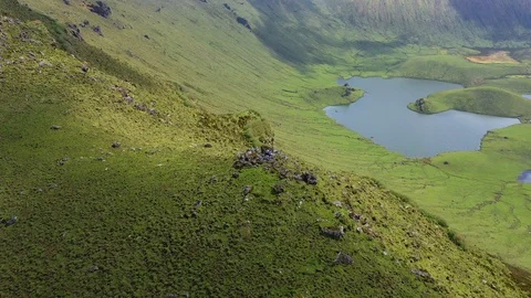 Two people on the top ov volcano in ocean. Aerial of green Caldeirao and its Stock Footage 119892001