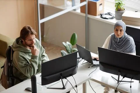 Two People Using Computers at Desk in Office with Wall Separations Foto stock
