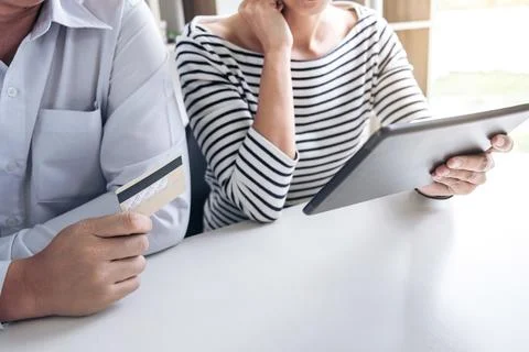 Two people using tablet and credit/debit card register payments online shop.. Stock Photos