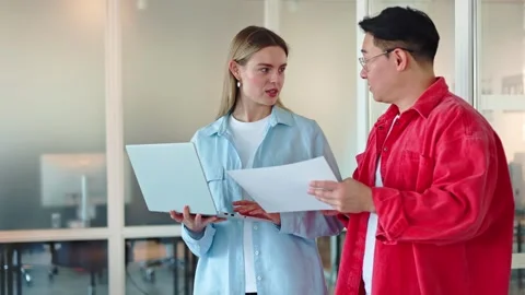 Two people utilizing technologies and documents to discussing working process Stock Footage 276424082