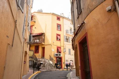 Two people walk away round corner in old part of city Stock Photos