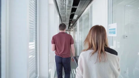 Two people walk through a corridor 스톡 동영상 289392303