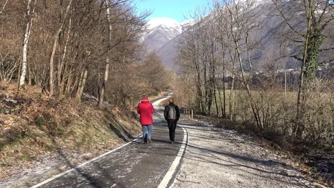 Two people walking on the cycle route of Valsassina, winter time Video stock 150560060