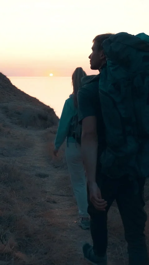 The two people walking down the mountain to the sea shore. slow motion Stock Footage 242239264