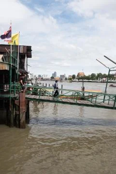 Two people walking down a pier on the river in Bangkok, Thailand Foto stock