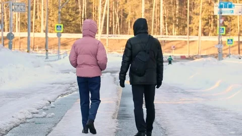 Two people walking on an empty winter road Stock Footage 172417117